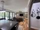 Open-concept living and dining area with hardwood floors, a brick accent wall, and sliding glass doors to the patio at 16 Mountain Creek Ne Trl, Fairmount, GA 30139