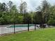 Backyard pool area with lounge chairs, surrounded by a black fence, and lush landscaping at 16 Mountain Creek Ne Trl, Fairmount, GA 30139