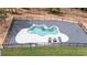 Backyard view of an in ground swimming pool surrounded by dark landscaping stone and black fence at 16 Mountain Creek Ne Trl, Fairmount, GA 30139