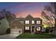 Charming brick home at sunset featuring a well-manicured lawn and a cozy front porch, perfect for relaxing at 2710 Irwin Ct, Cumming, GA 30041