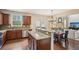 Open eat-in kitchen with stainless appliances, stone countertops, and connection to the living area at 2710 Irwin Ct, Cumming, GA 30041