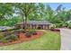Attractive brick home featuring mature trees, a well-kept lawn, and charming landscaping at 1405 Murdock Rd, Marietta, GA 30062