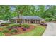 Charming home featuring a well-manicured front yard with lush landscaping, mature trees, and a welcoming entrance at 1405 Murdock Rd, Marietta, GA 30062