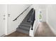 Bright and airy staircase with wooden floors and black iron railings leading to the upper level at 160 Fowler St # 100, Woodstock, GA 30188