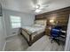 Cozy bedroom with hardwood floors, ceiling fan, and a rustic wood accent wall at 1939 Suwanee Valley Rd, Lawrenceville, GA 30043