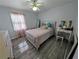 Cozy bedroom with hardwood floors, and vanity with great natural light from the window at 1939 Suwanee Valley Rd, Lawrenceville, GA 30043