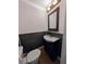 Elegant powder room featuring a vessel sink, dark wainscoting, and decorative mirror at 1939 Suwanee Valley Rd, Lawrenceville, GA 30043