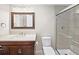 Modern bathroom featuring a vanity with a quartz countertop, mirror, and walk-in shower with glass doors at 2178 Tanglewood Rd, Decatur, GA 30033