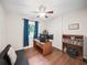 Bright bedroom with hardwood floors, blue curtains, a ceiling fan, and comfortable sitting area at 2178 Tanglewood Rd, Decatur, GA 30033