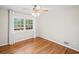 Bright bedroom featuring hardwood floors, a ceiling fan, and a large window offering natural light at 2178 Tanglewood Rd, Decatur, GA 30033