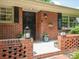 Cozy front porch featuring brick detail, lantern decor, and a decorative wrought iron security door at 2178 Tanglewood Rd, Decatur, GA 30033