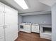 Well-lit laundry room with white cabinetry, a utility sink, and modern washer and dryer at 2178 Tanglewood Rd, Decatur, GA 30033
