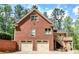 Two-story brick home showcasing a two-car garage and upper level deck at 349 Harris Loop, Dallas, GA 30157