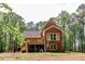 Brick two-story home with a wooden deck, screened in porch, and lush green trees at 349 Harris Loop, Dallas, GA 30157
