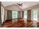 Bright living room with hardwood floors, vaulted ceilings, ceiling fan, and large windows offering natural light at 349 Harris Loop, Dallas, GA 30157