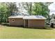 View of rear detached storage shed with metal roof and lawn at 349 Harris Loop, Dallas, GA 30157