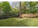 View of a backyard featuring a lawn, wooden fence, and some trees and foliage at 134 Woodlawn Ave, Decatur, GA 30030