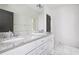 Bright bathroom featuring double vanity with granite countertop, white cabinets, and a large mirror at 134 Woodlawn Ave, Decatur, GA 30030