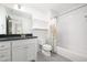 Bathroom featuring white tiled walls, grey floors, vanity, toilet, and shower with decorative curtain at 134 Woodlawn Ave, Decatur, GA 30030