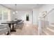 Open-concept dining room with hardwood floors, modern chandelier, and view of staircase and living room at 134 Woodlawn Ave, Decatur, GA 30030