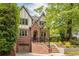 Charming brick home featuring a two-car garage, lush landscaping, and a welcoming entrance, exuding curb appeal at 134 Woodlawn Ave, Decatur, GA 30030