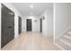Hallway with grey doors, light floors, white walls, staircase, and modern light fixtures at 134 Woodlawn Ave, Decatur, GA 30030