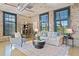 Open living area showcases exposed brick, tall windows, and stylish furnishings, creating a warm and inviting atmosphere at 170 Boulevard Se # E414, Atlanta, GA 30312