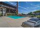 Poolside view with comfortable lounge chairs, umbrellas, and unique industrial buildings in the background at 170 Boulevard Se # E414, Atlanta, GA 30312