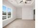 Bright bedroom featuring large windows, tray ceiling, ceiling fan, and carpeted floor at 2215 Nena Way # 20, Tucker, GA 30084