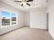 Carpeted bedroom featuring tray ceiling, ceiling fan and large window at 2215 Nena Way # 20, Tucker, GA 30084