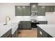 Modern kitchen boasts stylish green cabinets, stainless steel appliances, and bright white countertops at 2215 Nena Way # 20, Tucker, GA 30084