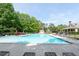 Community pool featuring multiple lounge chairs, shade umbrellas, manicured landscaping, and a playground at 238 Diamond Valley Pass, Canton, GA 30114
