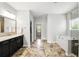 Bright bathroom featuring a bathtub, dark cabinets, and a large mirror over the vanity at 345 Varenna Ln, Sugar Hill, GA 30518