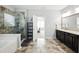 Bathroom featuring a modern glass shower, a soaking tub, double vanity, and dark cabinets at 345 Varenna Ln, Sugar Hill, GA 30518