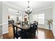Bright dining room featuring hardwood floors, a chandelier, and a view into the living room at 345 Varenna Ln, Sugar Hill, GA 30518
