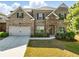 Charming two-story brick home with landscaped front yard and a two-car garage at 345 Varenna Ln, Sugar Hill, GA 30518