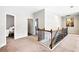 Upstairs hallway featuring carpet and open doorways to bedrooms at 345 Varenna Ln, Sugar Hill, GA 30518