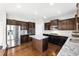 Modern kitchen with stainless steel appliances, granite counters, and dark wood cabinets at 345 Varenna Ln, Sugar Hill, GA 30518