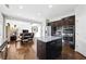 Open-concept kitchen with stainless steel appliances, granite countertops, and a view to the living room fireplace at 345 Varenna Ln, Sugar Hill, GA 30518