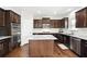 Updated kitchen featuring granite counters, stainless steel appliances, a center island, and warm wood cabinetry at 345 Varenna Ln, Sugar Hill, GA 30518