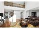 Sun-filled living room with hardwood floors, offering views of the staircase and adjoining kitchen and dining areas at 345 Varenna Ln, Sugar Hill, GA 30518