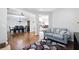 Open-concept living room featuring hardwood floors, a stylish area rug and views of the dining room and staircase at 345 Varenna Ln, Sugar Hill, GA 30518
