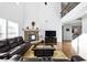 Spacious living room with a stone fireplace, hardwood floors, and an open view to the second-floor balcony at 345 Varenna Ln, Sugar Hill, GA 30518