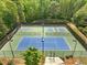 Overhead view of tennis and basketball courts with lush trees surrounding the area at 345 Varenna Ln, Sugar Hill, GA 30518