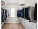 Well-organized walk-in closet with shelving and hanging rods, natural light from the window at 345 Varenna Ln, Sugar Hill, GA 30518
