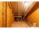 An unfinished attic shows exposed wooden beams, insulation, and building materials, showing potential storage at 555 Letchas Ln, Alpharetta, GA 30009