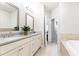 Bright bathroom with a double vanity, soaking tub, tiled floors, and modern fixtures and finishes at 555 Letchas Ln, Alpharetta, GA 30009
