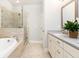 A luxurious bathroom boasts a separate glass shower, soaking tub, and double vanity with modern finishes at 555 Letchas Ln, Alpharetta, GA 30009