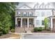 Charming two-story brick home featuring a cozy front porch, black shutters, and manicured landscaping at 555 Letchas Ln, Alpharetta, GA 30009