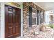 Charming brick front porch with dark wood door, black shutters, and decorative accents at 555 Letchas Ln, Alpharetta, GA 30009